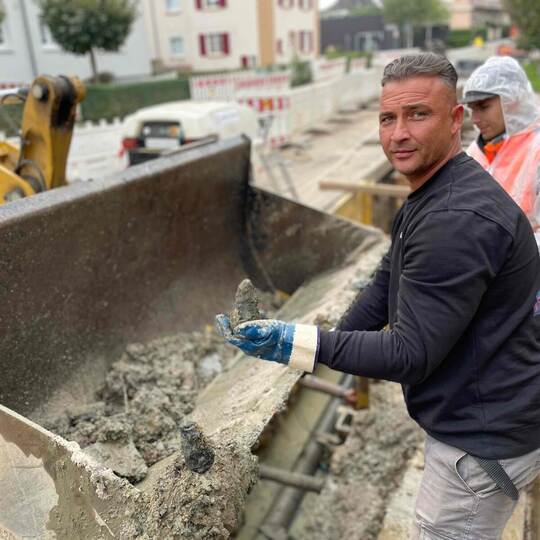 Nicolas Rupp (im Hintergrund) spült mit Wasser. Feuerwerker Roman Walth wühlt mit den Händen, um herauszufinden, ob noch mehr Zü